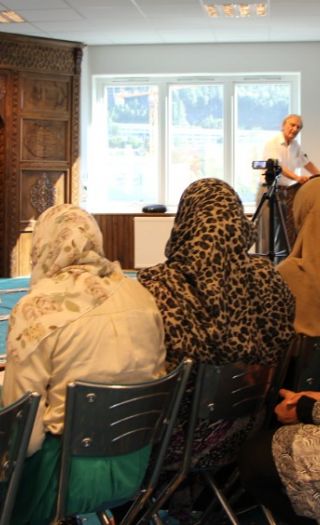 Tumyr på talerstolen i moskeen til Minhaj-ul-Quran