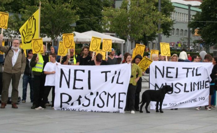 De ropte så taktfast - medlemmene av SOS Rasisme: «Ingen rasister i våre gater». «Nye SOS Rasisme» har nå kommet opp - I Kristiansand vil vel ropene lyde: «Ingen rasister i våre biblioteker!»